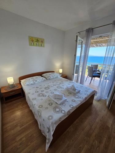 a bedroom with a bed with a view of the ocean at Apartments Sea and Pine in Ivan Dolac