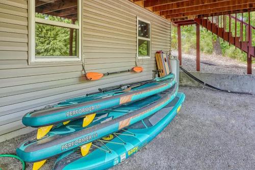 three kayaks are lined up on the side of a house at Lakefront Retreat - Near Trails & Family Fun in Bella Vista