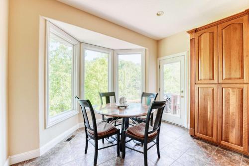 a dining room with a table and chairs and windows at Lakefront Retreat - Near Trails & Family Fun in Bella Vista