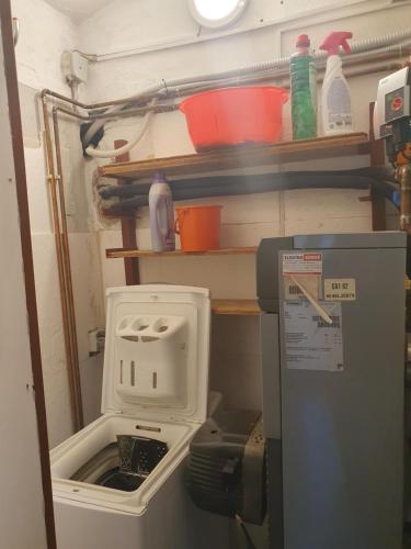 a small kitchen with a refrigerator with a toaster at Brookside Old Village Studio at a walking distance from Bled in Bohinjska Bela