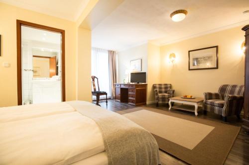 a hotel room with a bed and a living room at Schökel´s Hotel und Restaurant in Elze