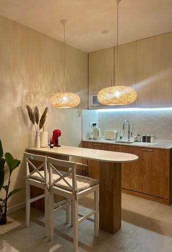 a kitchen with two pendant lights and a table at Sea View Dream Apartment in BambooBeach Tsikhisdziri in Tsikhisdziri