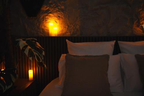 a bedroom with a bed with white pillows and a lamp at Private Hammam & Immersive Cinema - Eden Luxury Suite in Roanne