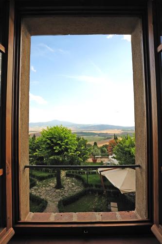 a window with a view of a garden at Relais Il Chiostro Di Pienza in Pienza