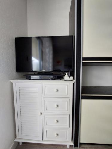 - une commode blanche avec une télévision en haut dans l'établissement Studio 50M plage, à La Baule
