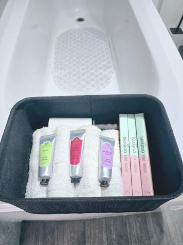 a suitcase with four different colored toothbrushes and books at Peckham City Vibes 2BR with Wi-fi and Balcony in London
