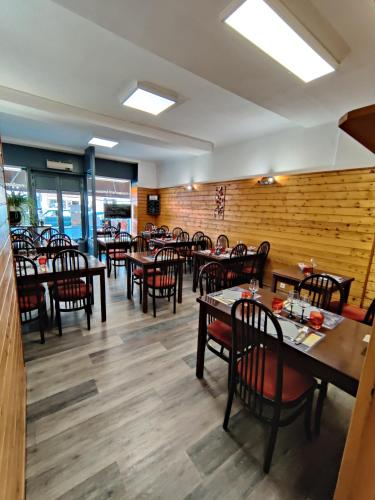 une salle à manger avec des tables et des chaises en bois dans l'établissement Hôtel Saint - Pierre, à Villedieu-les-Poêles