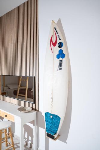 a surfboard hanging on a wall next to a table at Pension Romantika in Matala