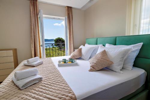a bedroom with a large bed with white pillows and a window at Villa 3D by the Sea with pool and included breakfast in Kaštela