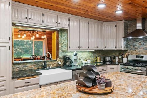 a kitchen with white cabinets and a marble counter top at Private Island Fire Pit & Arcade in Rigby