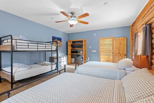 a bedroom with two bunk beds and a ceiling fan at Private Island Fire Pit & Arcade in Rigby