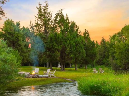 a fire pit in a park next to a river at Private Island Fire Pit & Arcade in Rigby