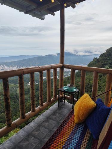 a balcony with a table and a view of the mountains at RIYA Tesoro de la montaña Cabaña Armonia in Ibagué