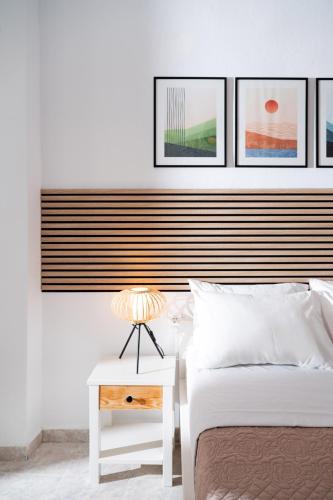 a bedroom with two beds and a table with a lamp at Pension Romantika in Matala