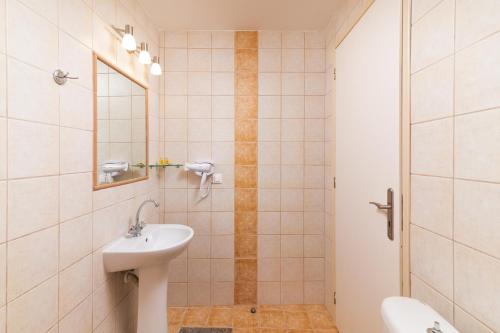 a bathroom with a sink and a mirror at Pension Romantika in Matala
