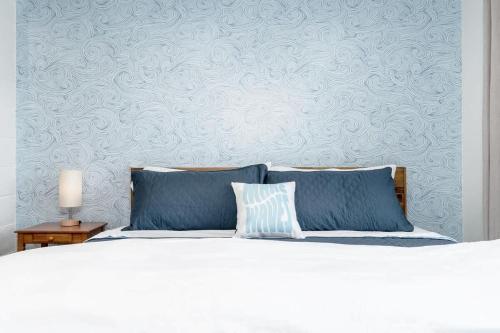 a bedroom with a bed with blue pillows and a wall at Downtown Lava - Views Huge Yard Slide Games in Lava Hot Springs