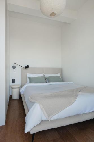a white bedroom with a bed and a lamp at Stone Suite Zakopane in Zakopane