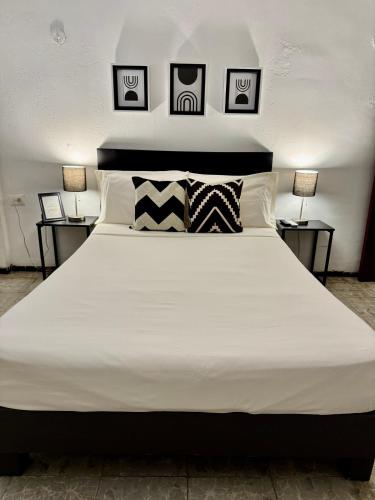 a large bed with white sheets and pillows at Mona Lisa in Mérida