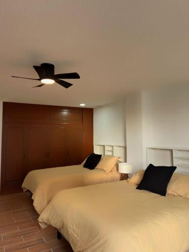 a bedroom with two beds and a ceiling fan at Habitacion Berlin en The Green Door in Aguascalientes
