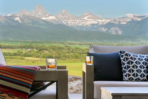 a living room with a couch and a table and mountains at Luxury Retreat Epic Views & Hot Tub in Tetonia