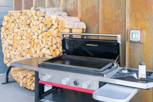 a grill in front of a pile of wood at Luxury Retreat Epic Views & Hot Tub in Tetonia