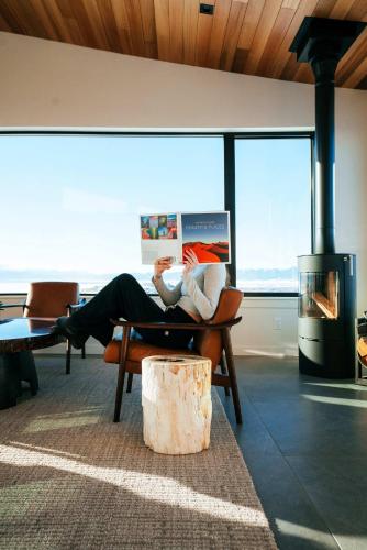 a person sitting on a chair in a room with a fireplace at Luxury Retreat Epic Views & Hot Tub in Tetonia