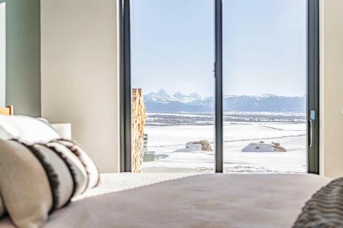 a bedroom with a bed with a view of snow covered mountains at Luxury Retreat Epic Views & Hot Tub in Tetonia