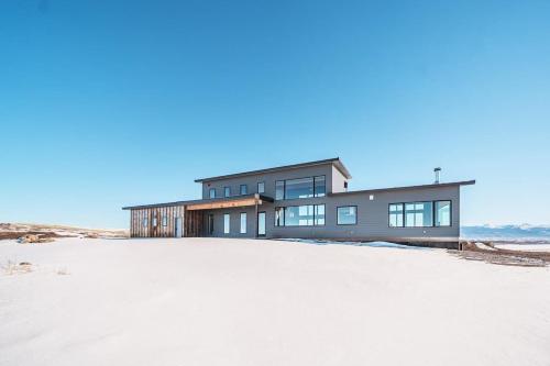 a house on top of a sandy field at Luxury Retreat Epic Views & Hot Tub in Tetonia
