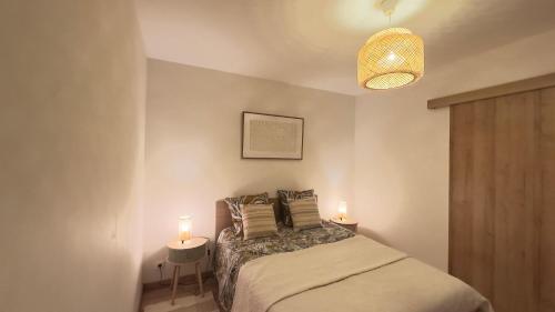 une chambre avec un lit avec deux lampes dessus dans l'établissement Magnifique Grand 2 Pièces moderne lumineux au calme avec grande terrasse à 15mn en bus Centre-ville, Gare et Promenade des Anglais, à Nice