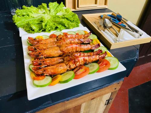a plate of grilled meat and vegetables on a table at Coastal villa in Batticaloa