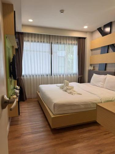 a bedroom with a large bed and a window at Dusit Grand Park 1 in Jomtien Beach