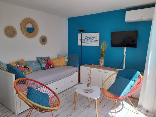 un salon avec un canapé et des chaises dans l'établissement Appartement cosy et lumineux à 50 m de la plage, au Cap d'Agde