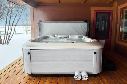 a white bath tub sitting on a wooden deck at Upscale Hot Tub Wildlife Views in Victor