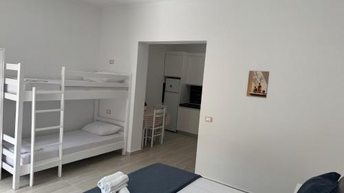 a small room with bunk beds and a kitchen at Amel's Apartments Comfortable Family Stay Near Orikum Beach in Orikum