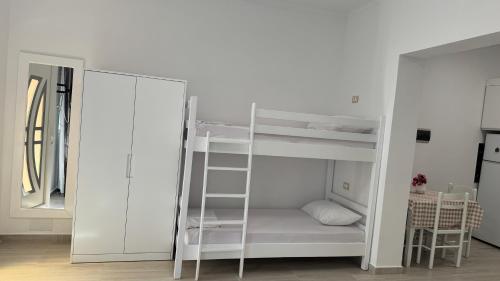 a white bunk bed in a room with a mirror at Amel's Apartments Comfortable Family Stay Near Orikum Beach in Orikum