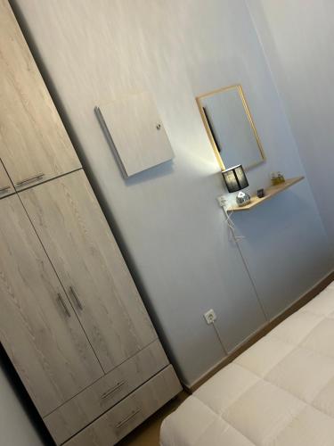 a white wall with a mirror and a cabinet at Apartment view sea artemida in Mesochórion