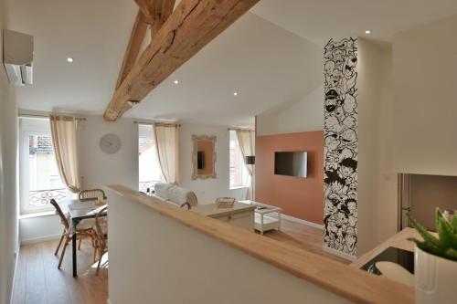 a living room and dining room with a long table at Cozy appartement in La Séguinière