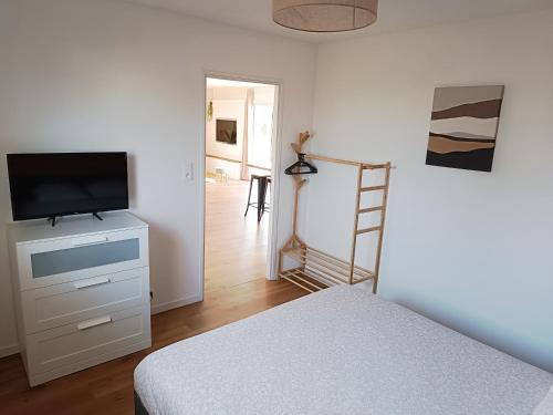 une chambre avec un lit et une télévision sur une commode dans l'établissement Vilin Tréompan à 400 m de la plage, à Ploudalmézeau