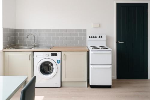 a kitchen with a washing machine and a sink at Modern 3 bed duplex apartment in Central Station