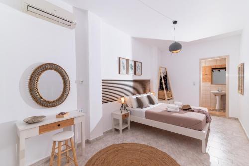 a bedroom with a bed and a desk and a mirror at Pension Romantika in Matala