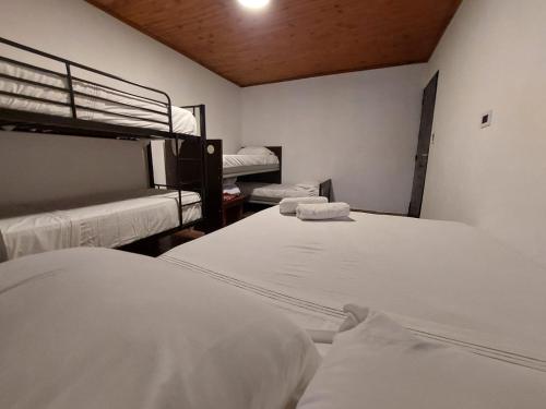 two beds in a room with two bunk beds at El Gran Gomero Hostal & Motoposada in Resistencia