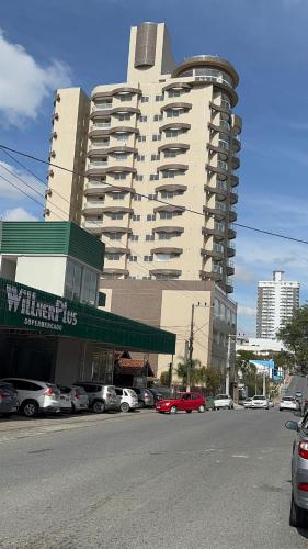 a large building with cars parked in a parking lot at Ap 803 Central Wi-Fi, Vista e Auto Check-in in Mafra
