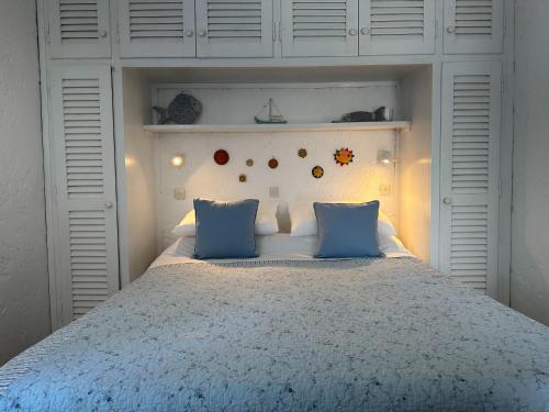 a bedroom with a large bed with blue pillows at Sea View Apartment in the Greek Nature in Gouvia