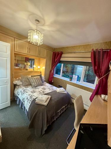 a bedroom with a bed and a chandelier at Station Approach B&B Boutique Stays in Solihull