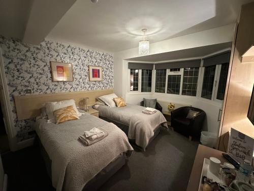 a hotel room with two beds and a chair at Station Approach B&B Boutique Stays in Solihull