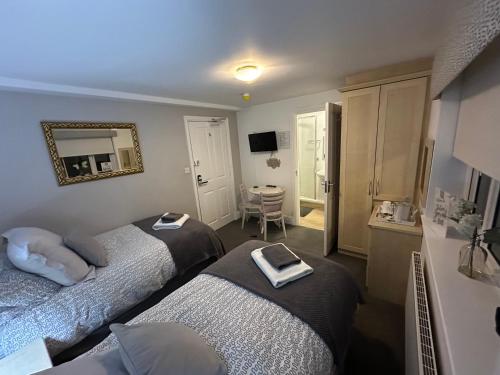 a hotel room with two beds and a mirror at Station Approach B&B Boutique Stays in Solihull