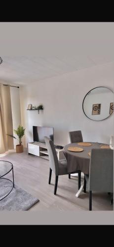 un salon avec une table, des chaises et une télévision dans l'établissement A deux pas du musee de l automobile, à Mulhouse