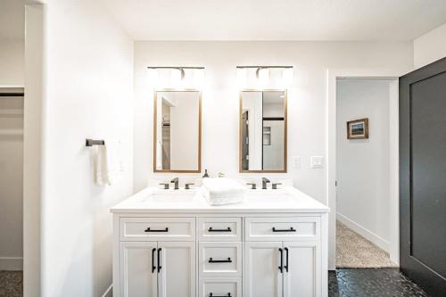 a bathroom with a white sink and two mirrors at Unique Townhome with AC Garage Patio in Driggs