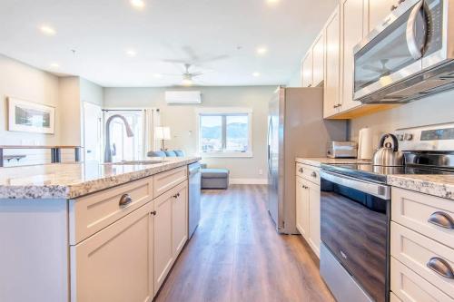 a large kitchen with white cabinets and wooden floors at Mtn Views Patio & South Fork Fun in Swan Valley