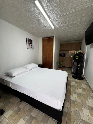 a bedroom with a large white bed in a room at Hermoso apartamento cerca al Poblado in Medellín